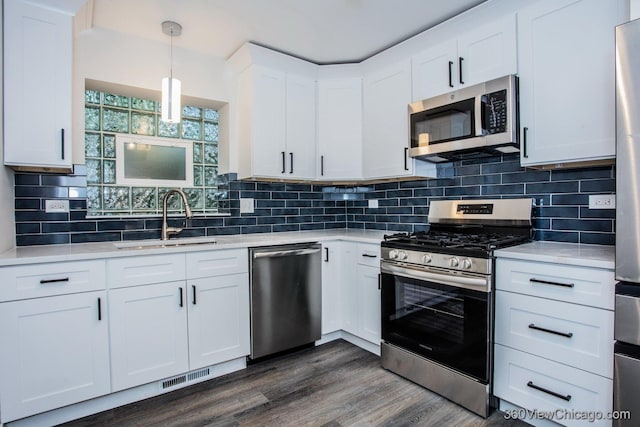 9206 S Yates Blvd, Chicago, IL 60617 - kitchen featuring appliances with stainless steel finishes, light countertops, white cabinets, and dark wood-style floors