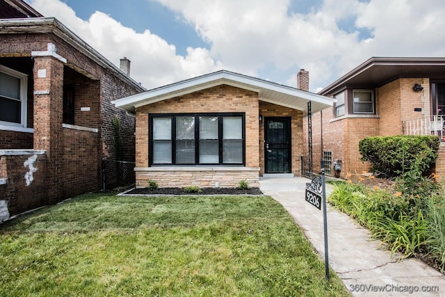 9206 S Yates Blvd, Chicago, IL 60617 - view of front of home featuring a chimney, a front lawn, and brick siding