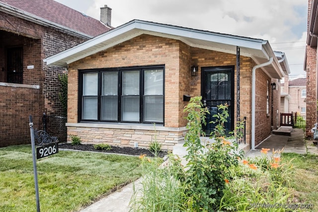 9206 S Yates Blvd, Chicago, IL 60617 - doorway to property with brick siding, a yard, and a chimney