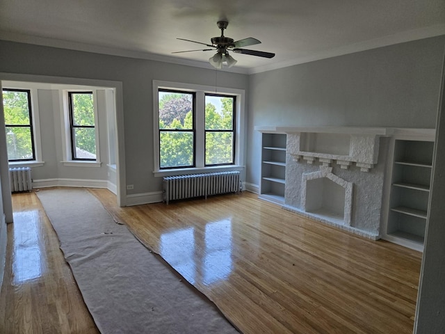 7543 S Yates Blvd, Chicago, IL 60649 - unfurnished living room with radiator, wood finished floors, ornamental molding, a ceiling fan, and a stone fireplace