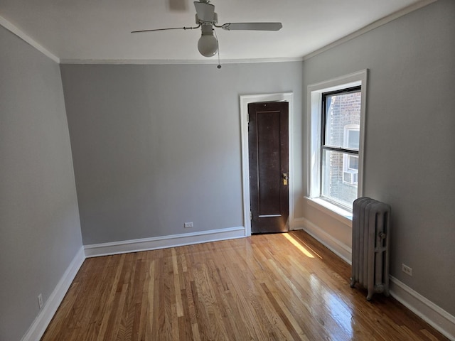 7543 S Yates Blvd, Chicago, IL 60649 - spare room featuring radiator, wood finished floors, a ceiling fan, and ornamental molding