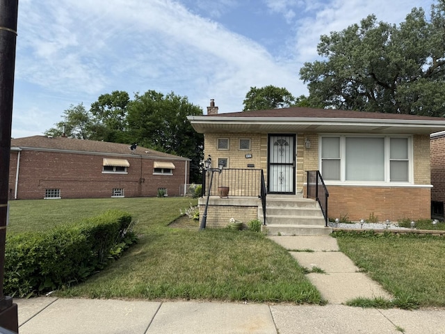 8114 S Anthony Ave, Chicago, IL 60617 - view of front of home featuring brick siding, a front yard, a chimney, and covered porch