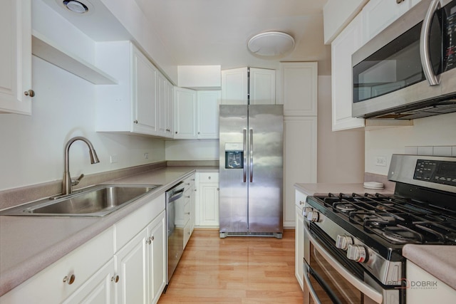 1499 Shermer Rd Unit 204E, Northbrook, IL 60062 - kitchen featuring appliances with stainless steel finishes, light wood-style floors, white cabinetry, and light countertops