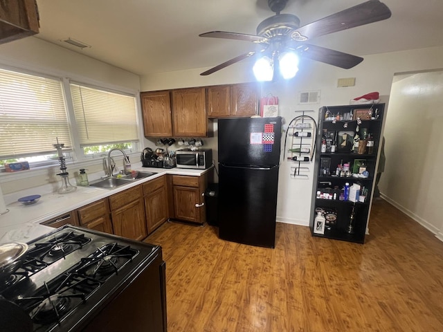 9013 La Crosse Ave, Skokie, IL 60077 - kitchen with black appliances, a ceiling fan, brown cabinets, and light countertops