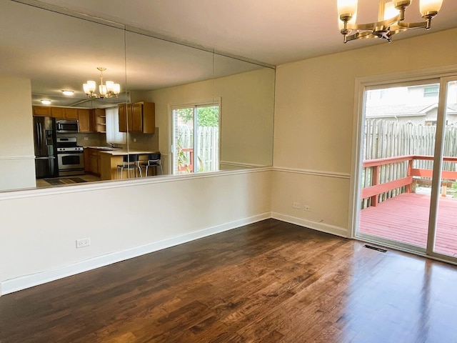 8148 W 111th St Unit C3, Palos Hills, IL 60465 - kitchen featuring a chandelier, appliances with stainless steel finishes, brown cabinetry, dark wood-style flooring, and pendant lighting