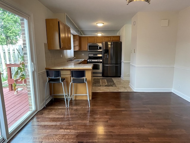8148 W 111th St Unit C3, Palos Hills, IL 60465 - kitchen with stainless steel appliances, wood finished floors, open shelves, a peninsula, and a kitchen breakfast bar