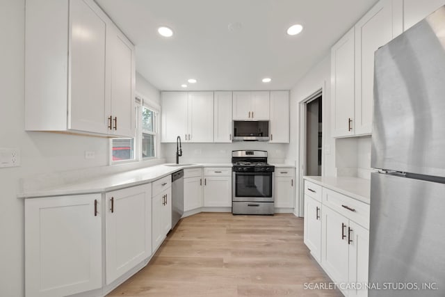 944 S Harvard Ave, Villa Park, IL 60181 - kitchen with stainless steel appliances, white cabinetry, light wood-type flooring, recessed lighting, and light countertops