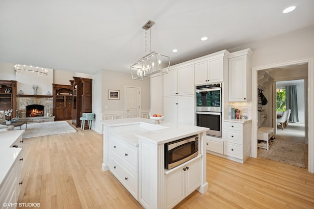 2007 Wilmette Ave, Wilmette, IL 60091 - kitchen featuring stainless steel appliances, light wood-style floors, a chandelier, white cabinets, and recessed lighting
