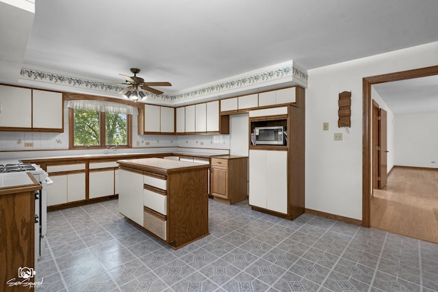 4849 W Kennedy Rd, Peotone, IL 60468 - kitchen with light countertops, ceiling fan, white gas range oven, stainless steel microwave, and white cabinetry