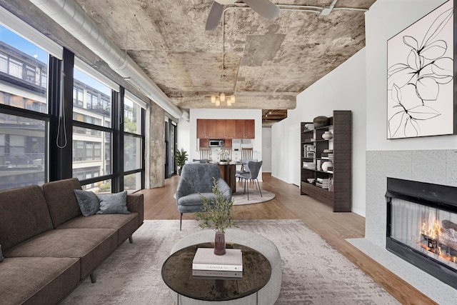 1070 W 15th St Unit 201, Chicago, IL 60608 - living room featuring light wood-style floors, a fireplace, and a ceiling fan