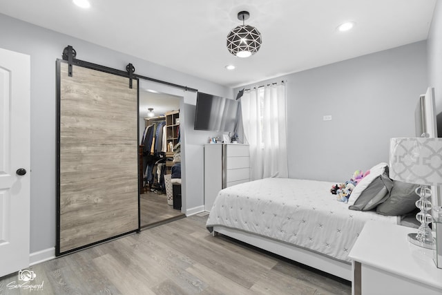 1318 S 6th Ave, Maywood, IL 60153 - bedroom featuring a barn door, wood finished floors, recessed lighting, and a spacious closet