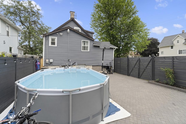 1318 S 6th Ave, Maywood, IL 60153 - back of property featuring a fenced backyard, a chimney, a patio, and a hot tub
