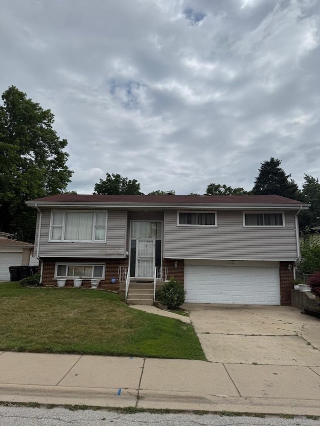15203 Waterman Dr, South Holland, IL 60473 - split foyer home featuring brick siding, driveway, a front yard, and an attached garage