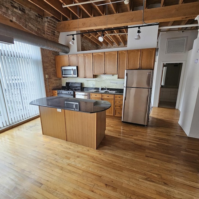420 S Clinton St Unit 607-A, Chicago, IL 60607 - kitchen featuring stainless steel appliances, dark countertops, a center island, wood-type flooring, and a high ceiling