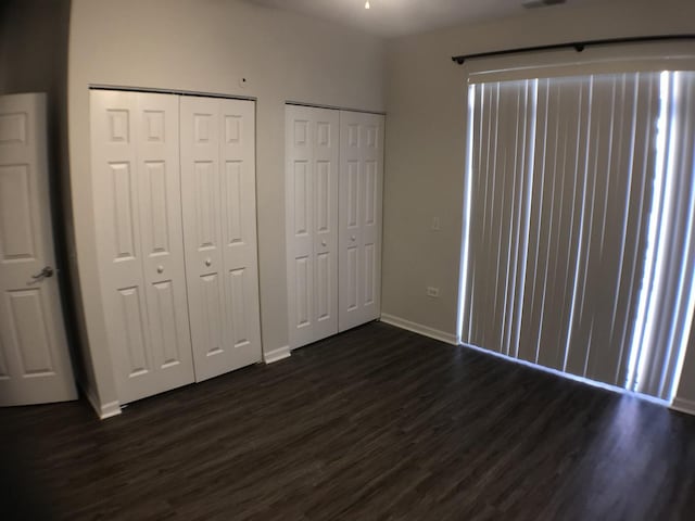 948 W 15th Pl Unit 1B, Chicago, IL 60608 - unfurnished bedroom featuring dark wood finished floors and two closets