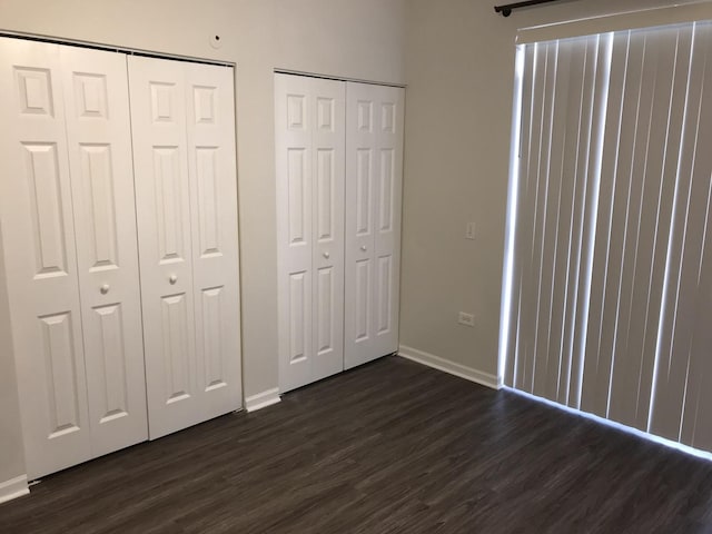 948 W 15th Pl Unit 1B, Chicago, IL 60608 - unfurnished bedroom with dark wood-type flooring and two closets