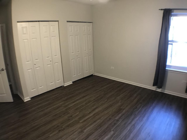 948 W 15th Pl Unit 1B, Chicago, IL 60608 - unfurnished bedroom featuring multiple closets and dark wood-style flooring
