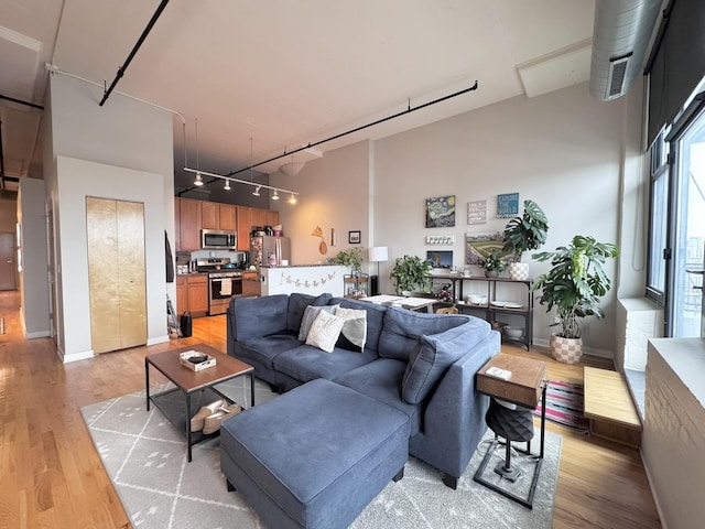 1224 W Van Buren St Unit 506, Chicago, IL 60607 - living area with rail lighting, light wood-style floors, and a high ceiling