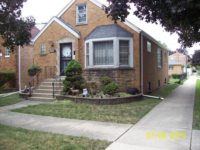view of front of home with brick siding and a front lawn