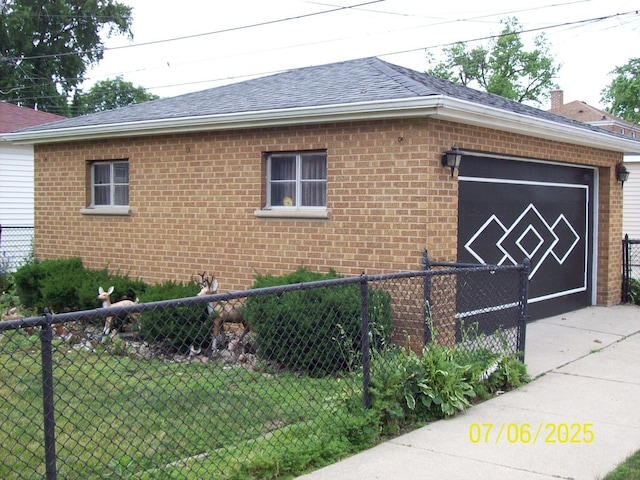 view of side of property with brick siding, roof with shingles, and driveway