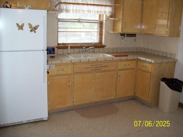 kitchen featuring freestanding refrigerator, open shelves, and tile countertops