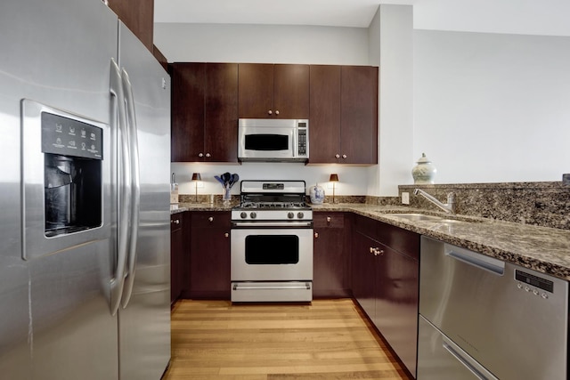 500 W Superior St Unit 1004, Chicago, IL 60654 - kitchen with appliances with stainless steel finishes, light wood finished floors, dark stone counters, and dark brown cabinets