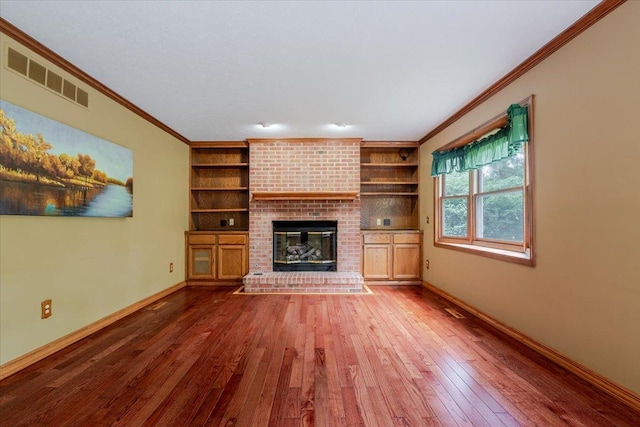 201 N Broadway St, Hudson, IL 61748 - unfurnished living room featuring ornamental molding, hardwood / wood-style flooring, a fireplace, and built in shelves