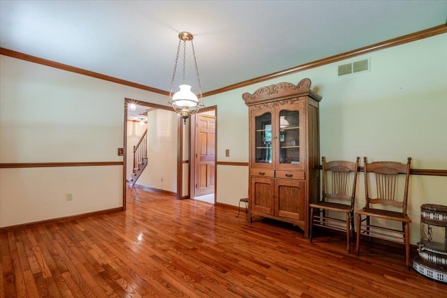 201 N Broadway St, Hudson, IL 61748 - empty room with wood finished floors, crown molding, and stairway