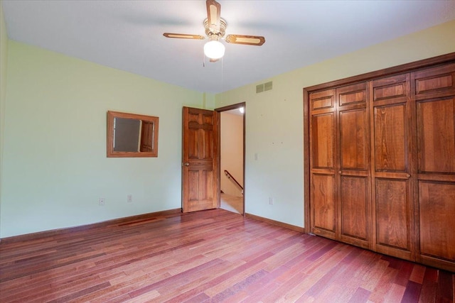 201 N Broadway St, Hudson, IL 61748 - unfurnished bedroom with light wood finished floors, ceiling fan, and a closet