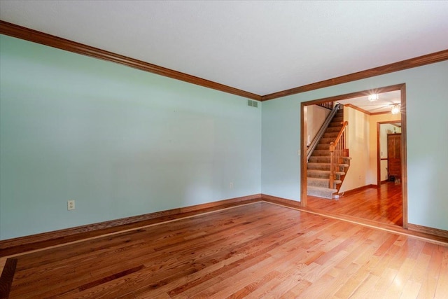 201 N Broadway St, Hudson, IL 61748 - spare room with ornamental molding, stairs, and light wood-style flooring