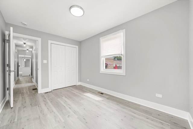 819 E 98th Pl, Chicago, IL 60628 - unfurnished bedroom with a closet and light wood-style flooring