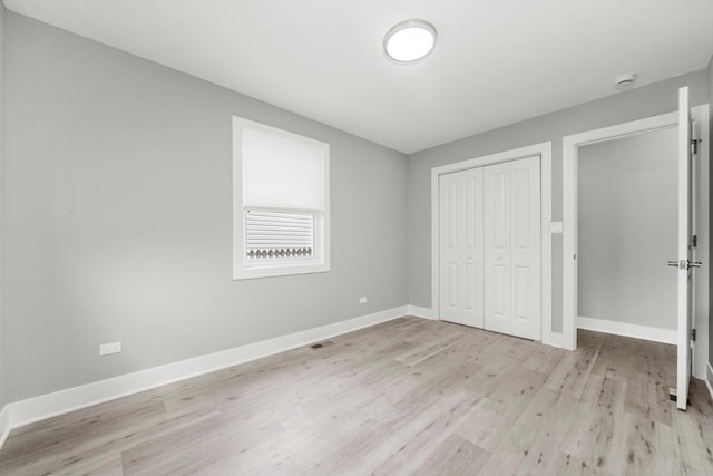 819 E 98th Pl, Chicago, IL 60628 - unfurnished bedroom featuring light wood-style flooring and a closet