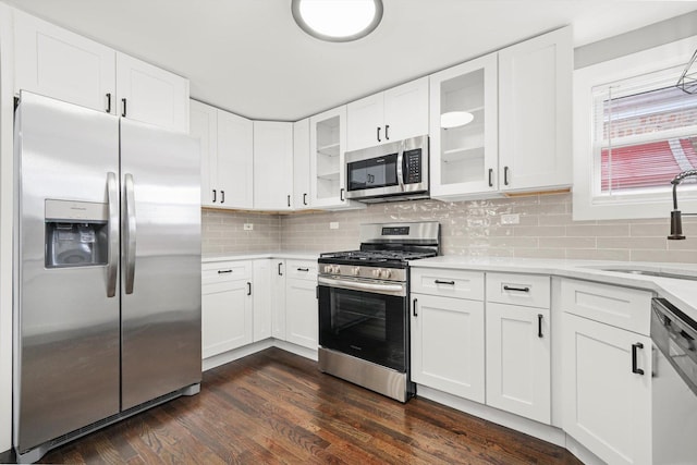 819 E 98th Pl, Chicago, IL 60628 - kitchen with stainless steel appliances, light countertops, glass insert cabinets, and white cabinetry