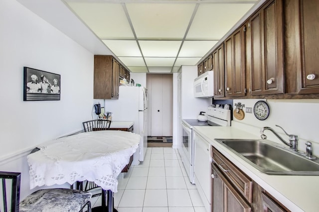 3925 Triumvera Dr Unit 14D, Glenview, IL 60025 - kitchen featuring white appliances, light countertops, light tile patterned flooring, and dark brown cabinets