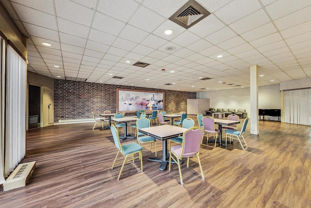 3925 Triumvera Dr Unit 14D, Glenview, IL 60025 - dining room featuring wood finished floors, a drop ceiling, and brick wall