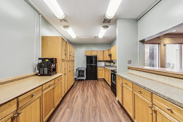 3925 Triumvera Dr Unit 14D, Glenview, IL 60025 - kitchen with wood finished floors, black appliances, and light countertops