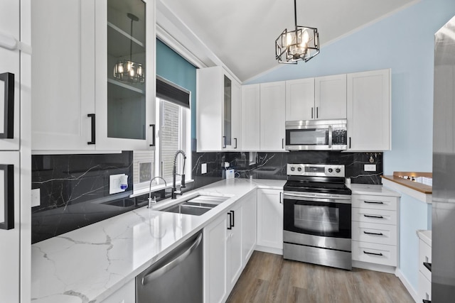 22514 Plum Creek Dr, Sauk Village, IL 60411 - kitchen with appliances with stainless steel finishes, vaulted ceiling, white cabinetry, light stone counters, and glass insert cabinets