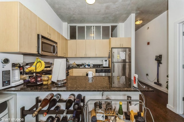 235 W Van Buren St Unit 1705, Chicago, IL 60607 - kitchen with stainless steel appliances, a peninsula, light brown cabinetry, and dark stone countertops
