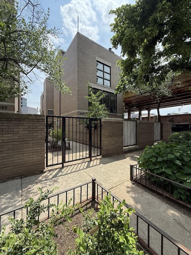 937 W Wrightwood Ave Unit C, Chicago, IL 60614 - view of side of home featuring a gate, a fenced front yard, and brick siding