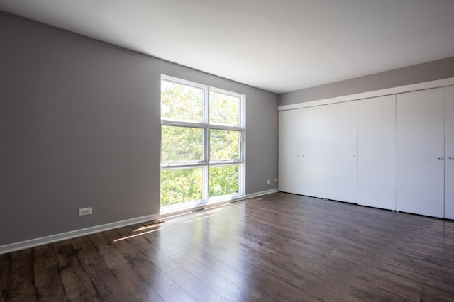 937 W Wrightwood Ave Unit C, Chicago, IL 60614 - unfurnished bedroom featuring multiple windows, dark wood-style floors, and a closet
