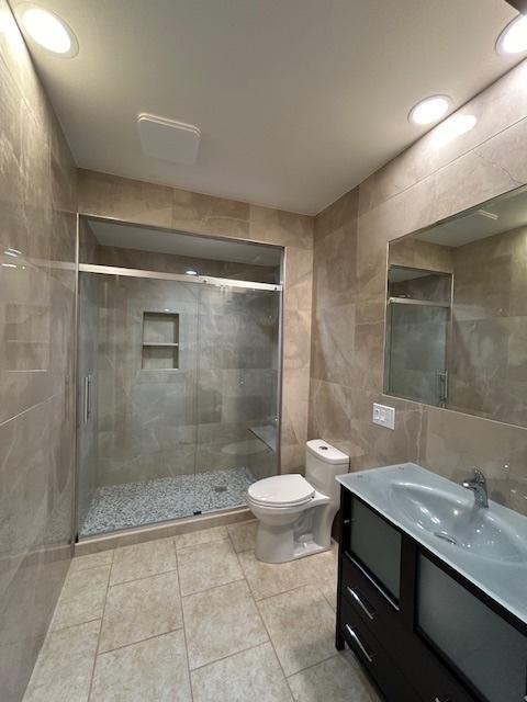 2277 S Westwood Ln, Palatine, IL 60067 - full bathroom featuring tile walls, vanity, a shower stall, and tile patterned floors