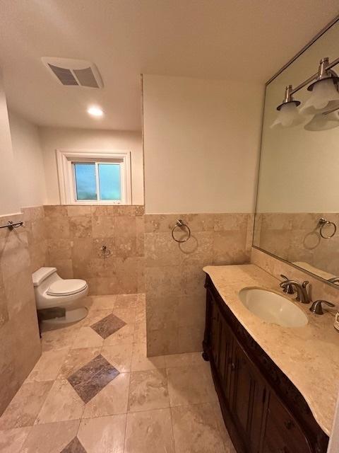 2277 S Westwood Ln, Palatine, IL 60067 - bathroom featuring tile walls, vanity, wainscoting, and tile patterned floors