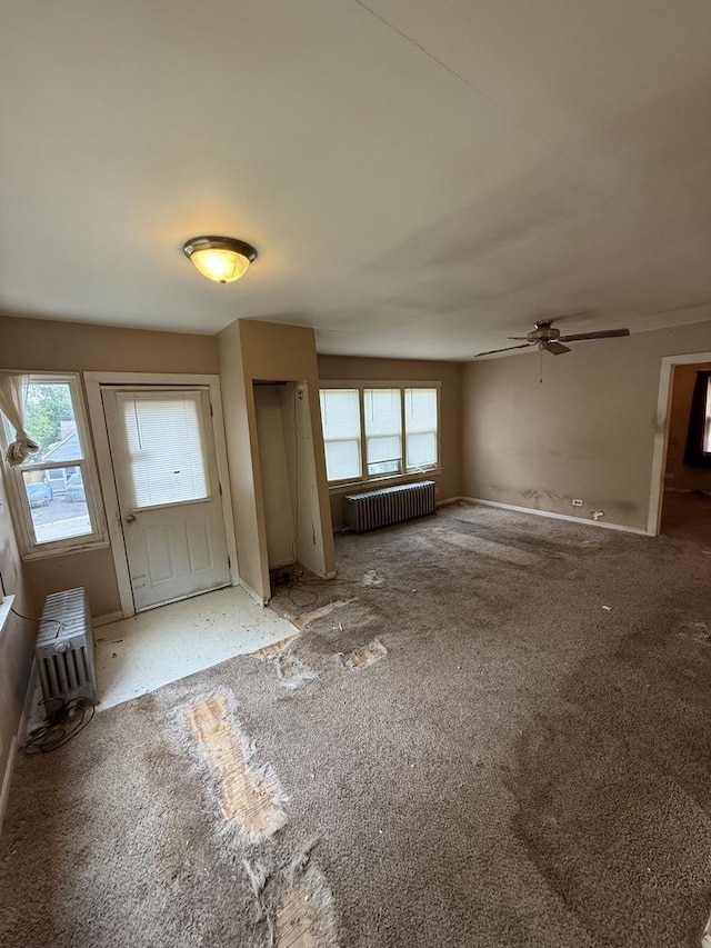 526 Grandview Dr, Round Lake Park, IL 60073 - unfurnished living room featuring radiator heating unit, a ceiling fan, and carpet floors