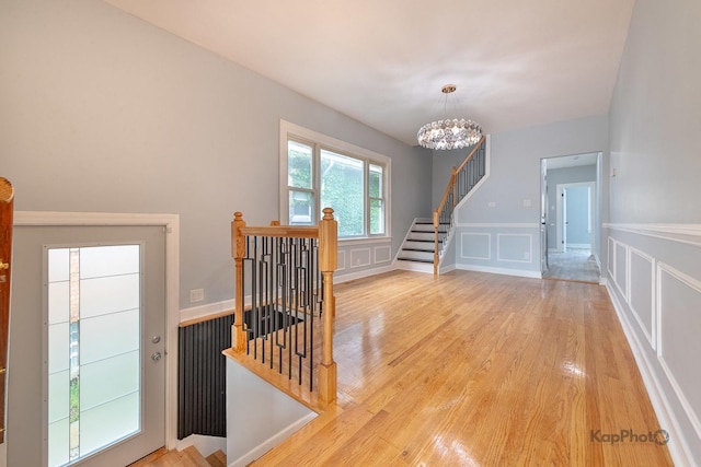 9340 S Elizabeth St, Chicago, IL 60620 - hall with light wood-style flooring, a chandelier, a decorative wall, an upstairs landing, and wainscoting