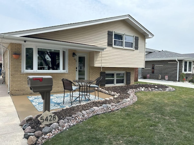 5428 138th St, Crestwood, IL 60418 - tri-level home featuring a patio, a front lawn, and brick siding