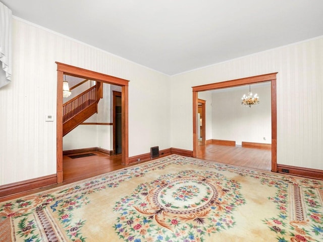 31 Bluff Ave, La Grange, IL 60525 - empty room featuring wood finished floors, ornamental molding, a chandelier, and stairway