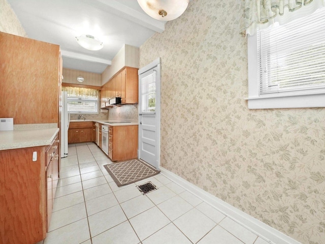31 Bluff Ave, La Grange, IL 60525 - kitchen with beamed ceiling, light countertops, light tile patterned floors, brown cabinetry, and white appliances