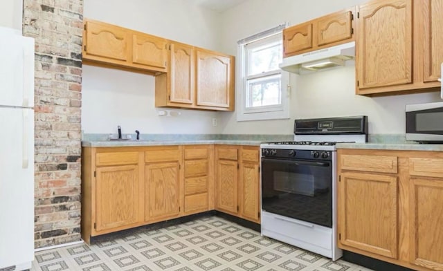 1010 N Prairie St, Bloomington, IL 61701 - kitchen featuring range with gas cooktop, stainless steel microwave, freestanding refrigerator, under cabinet range hood, and light countertops