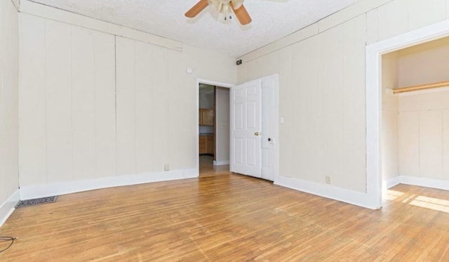 1010 N Prairie St, Bloomington, IL 61701 - unfurnished bedroom with wood finished floors, a decorative wall, and a ceiling fan