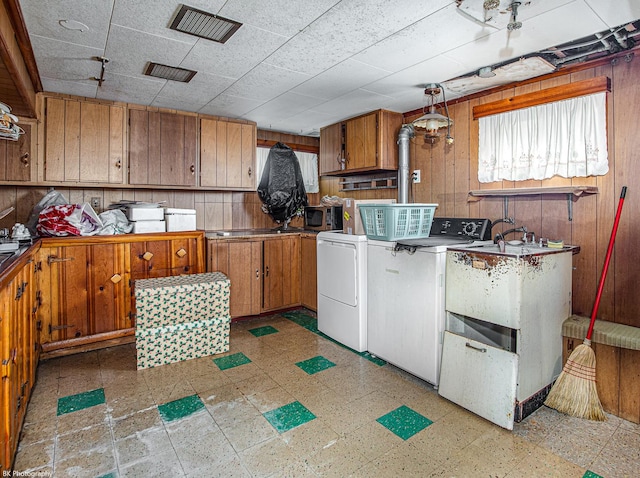 3855 W 107th St, Chicago, IL 60655 - laundry area with washing machine and clothes dryer, light flooring, wood walls, and cabinet space